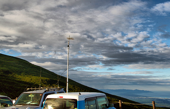 鳥海山五合目 鉾立 一般駐車場 西の端から二番目。アンテナは ビニテで仮留めした 5エレ クアトロ・ヘンテナ(4mH.)。写っている山は、山形/新潟県境の山。この右に妙高山や北アルプスも見えるはずだが、残念ながら霞んでしまっていた。
