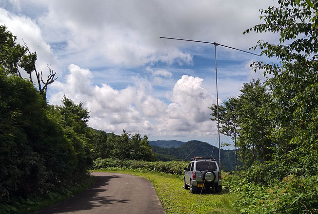 八峰町 青秋林道D 標高896m 南方向。クルマの前の山の向こうに 寒風山が見えるハズだが、かなり霞んでいる。